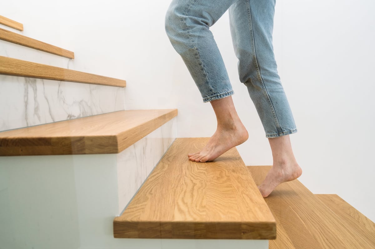 Rodillas de una persona al subir un escalón