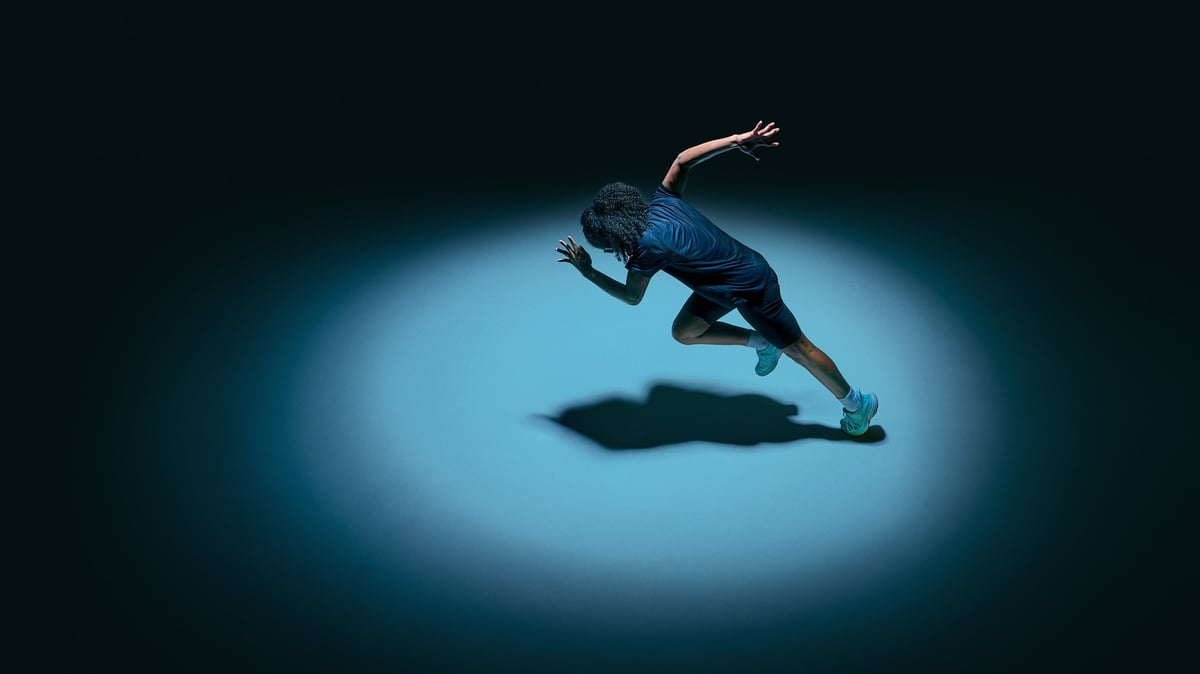 Deportista en pleno movimiento bajo un haz de luz